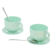 Load image into Gallery viewer, Two mint green ceramic teacups with matching saucers, each with a silver spoon, photographed on a clean white background.