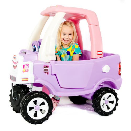 Child playing in a pink and purple toy car on a white background