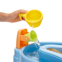 Load image into Gallery viewer, Child's hand pouring water from a yellow scoop into a blue sand and water table with a green bucket.