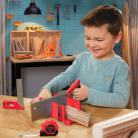 Load image into Gallery viewer, Boy playing with toy saw in a pretend workshop setting.