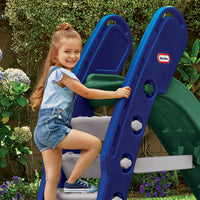 Load image into Gallery viewer, Young girl climbing a blue and green Little Tikes slide with plants and flowers in the background
