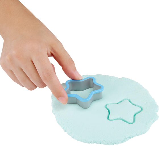 childs hand holding a cookie cutter in play dough