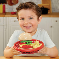 Load image into Gallery viewer, Child holding a toy hamburger set in a red basket in a kitchen setting
