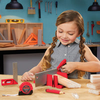 Load image into Gallery viewer, Girl using toy saw and other tools in a workshop setting
