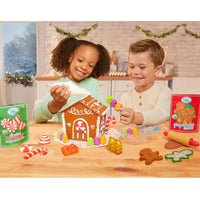 Load image into Gallery viewer, Two children playing with a gingerbread house kit
