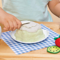 Load image into Gallery viewer, Child putting pretend frosting on cake on a checkered tablecloth

