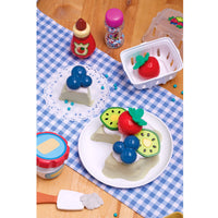 Load image into Gallery viewer, food set on a checkered tablecloth with various toy fruits and containers.

