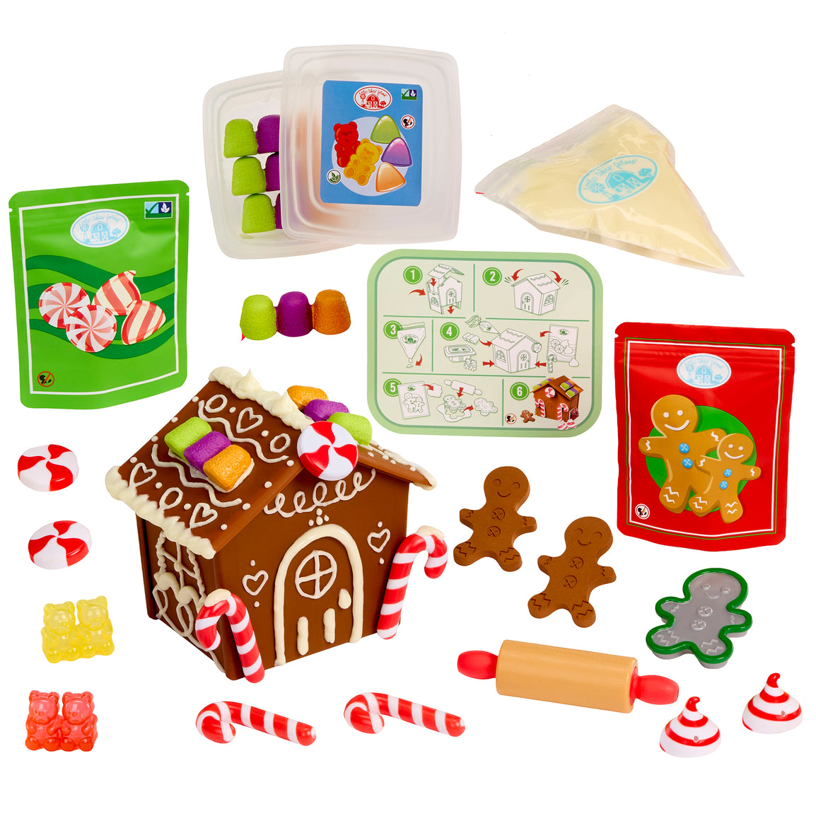 Collection of toy baking and decorating items including a gingerbread house, candy canes, and gingerbread men on a white background.