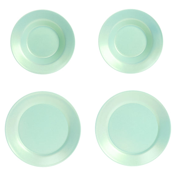 Four round light mint green plates arranged in a 2x2 grid on a plain white background.